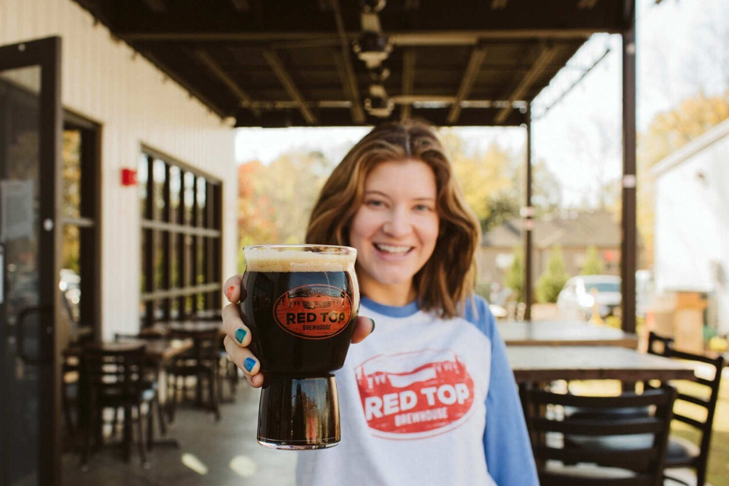Girls holds out beer at Red Top Brewhouse